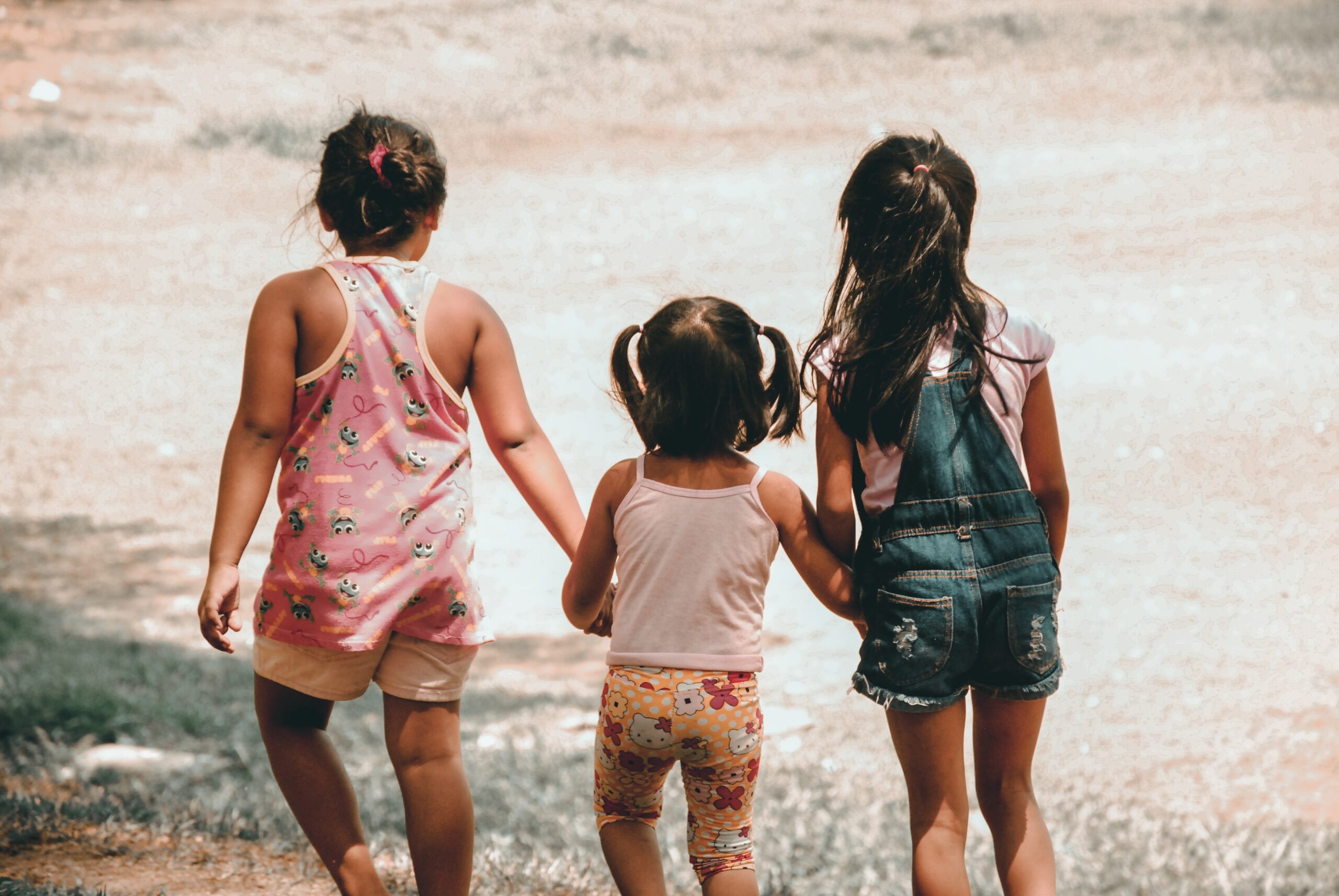 The back of three children walking in a field representing the family that was experiencing homelessness in South Jersey