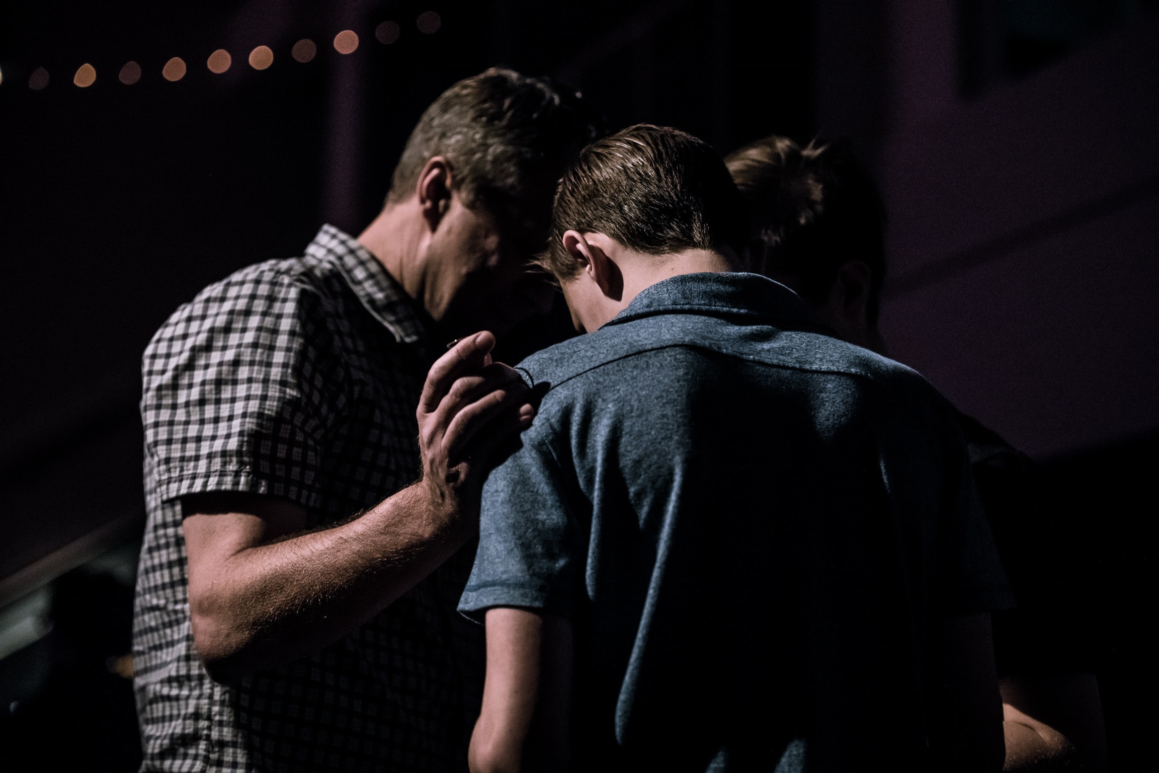 Family praying together to represent how Recovery Stations of the Cross can help everyone better understand addiction.
